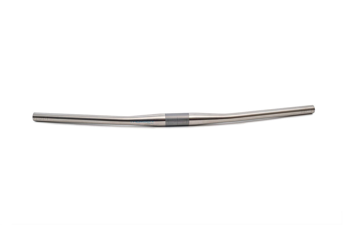 close up image of rider's view of Thomson Ti handlebar with green field behind it