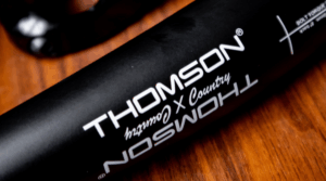 very close up image of thomson carbon handlebar on wood surface
