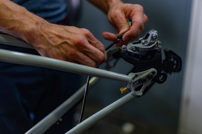 close up image of hands fixing a chain on a bike