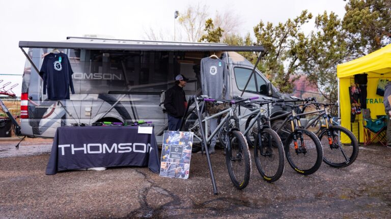 Thomson van acting as a pop up shop with 4 bikes in front of it and a table with a Thomson table cloth